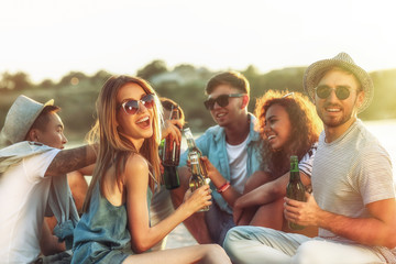 Group of friends hanging out with beer at the beach