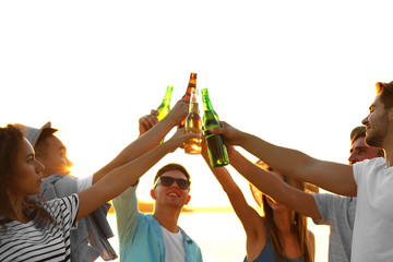 Group of friends hanging out with beer at the beach