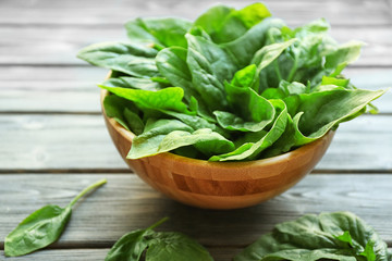 Fresh sorrel in bowl on wooden table