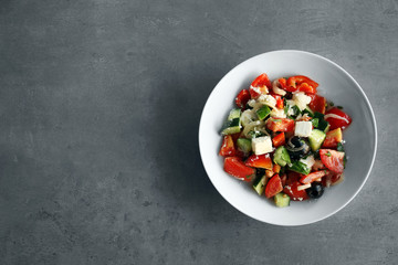Plate with tasty salad on gray table