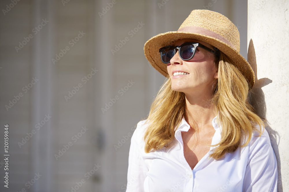 Wall mural confident woman smiling, portrait of a beautiful middle age lady enjoying a summer day outdoor.