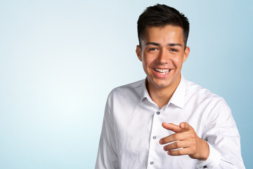 Portrait of a young man pointing his finger at you