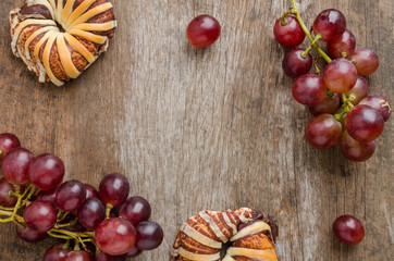 Chocolate croissants and fresh grape on old wooden table. Top vi
