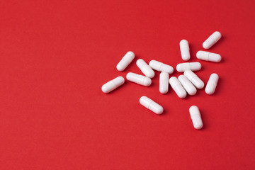 White capsules on red background