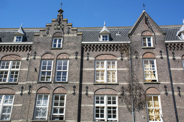 Fototapeta na wymiar Old brown historical buildings in Amsterdam in the day under the blue sky