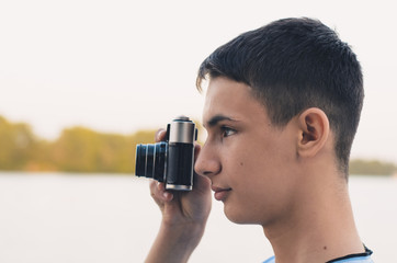 Fototapeta premium Cute boy teenager with vintage rangefinder camera.