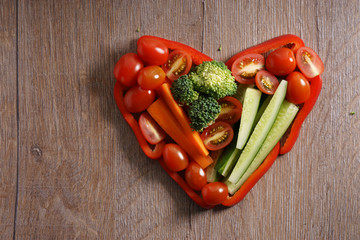 heart shaped colorful vegetable on wooden background
