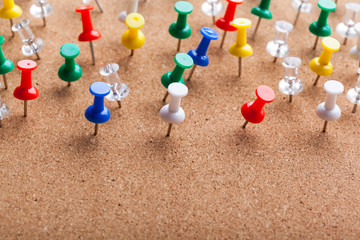 Group of thumbtacks pinned on corkboard