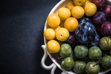vibrant and ripe plums in bowl