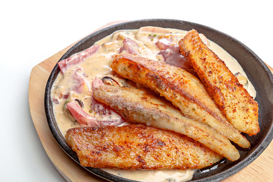 Baked fish  in a pan isolated on white