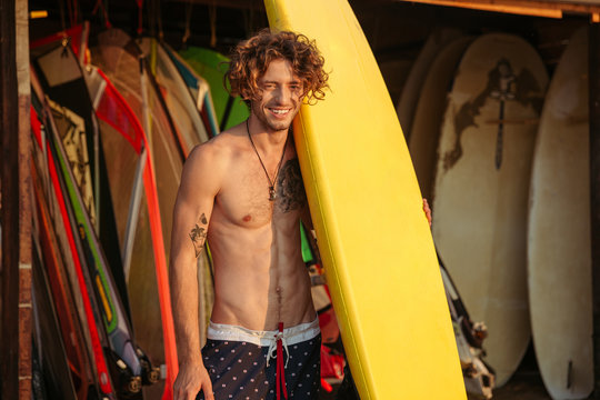 Portrait of a young surfer with surfboard