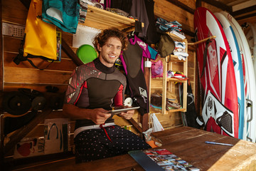 Nan in swimsuit using tablet while sitting in shack