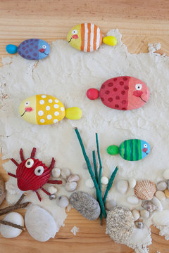 Painted stone fishes on the sand craft