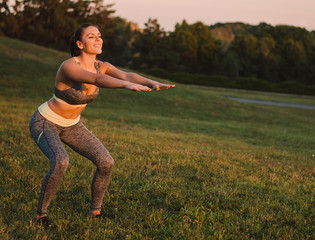 Attractive fitness woman practicing in the park on the grass. Sh