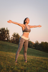 Obraz premium attractive young fitness woman practicing in the park. Sport con