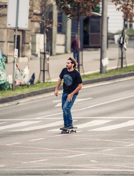 Professional skateboarder riding a skateboard on the capital city streets, through cars and urban traffic