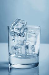 Glass with ice cubes toning photo blue studio shot