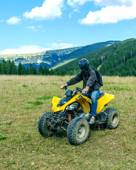Obraz premium Man at ATV Quad Bike on the mountains road