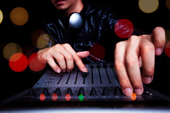 hands of DJ, producer working on digital studio mixer for night club, radio, TV broadcasting background