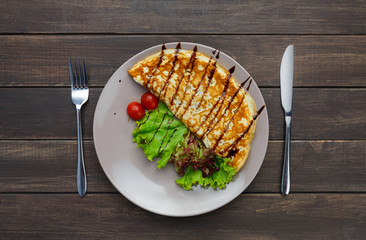 Restaurant food top view on wooden table. Omelette with vegetables