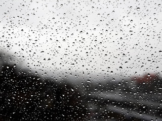 Raindrops on a window before an blurry background
