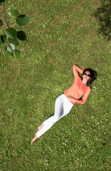 Top view. beautiful young brunette woman, lying in the grass