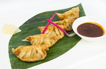 Japanese dumplings with lettuce on white background
