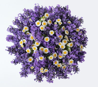 Fototapeta Top view of a bouquet of lavender and camomile flowers on a white background. Colorful summer bouquet of purple lavandula and yellow chamomile flowers. Photo from above.