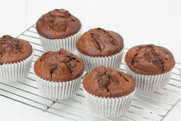 Homemade Chocolate Muffins In Paper Cases. White Table.