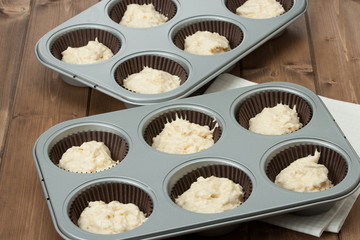 Baking Trays With Raw Muffin Dough In Paper Cases.