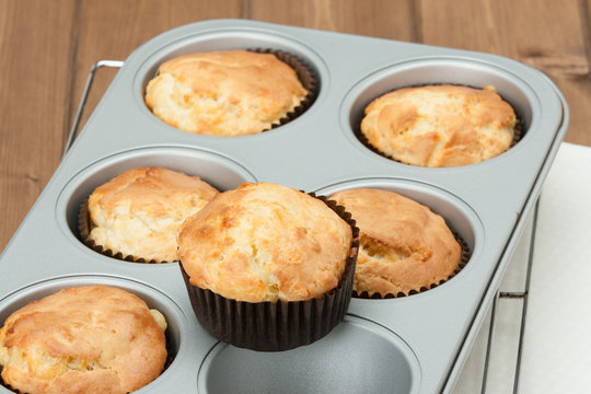 Homemade Cheddar Muffins In Baking Tray. Wooden Table.