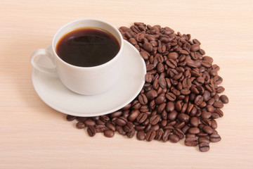 Coffee beans and a white cup on table