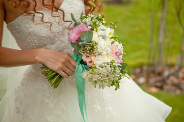 Close up of wedding bouquet of flowers holded by happy young bri
