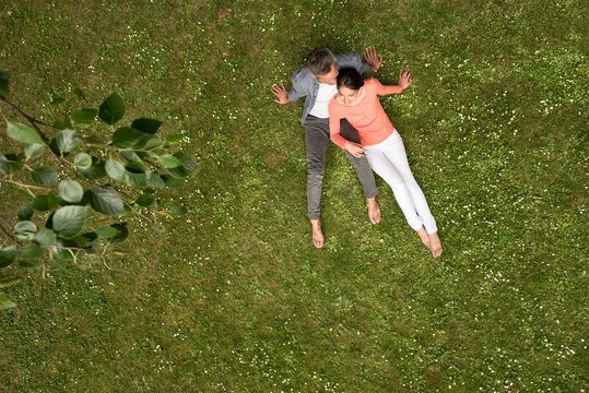 Top View. Handsome Young Couple Sitting In The Grass