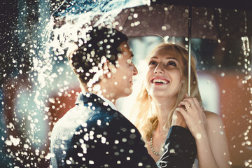 young couple standing under a big umbrella
