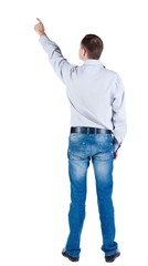 young man pointing at wall. rear view. Isolated over white .