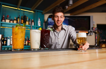 Young Barman offers non-alcoholic cocktails in night club bar