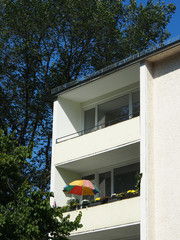 Bunter Sonnenschirm auf dem Balkon, 60er Jahre Mietshaus