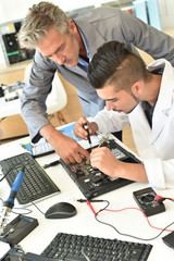 Student in electrical engineering course training with teacher