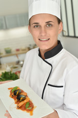 Young chef in cooking training school presenting dish