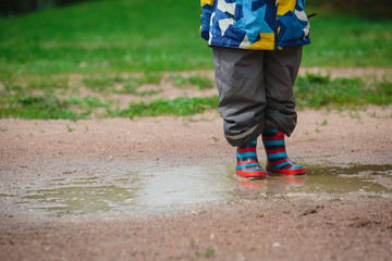Fototapeta na wymiar child playing in muddy puddle