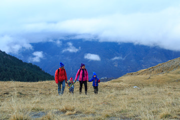 Fototapeta na wymiar family with two kids hiking in winter mountains