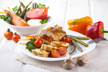 chicken rolls with tomato and paprika on white plate