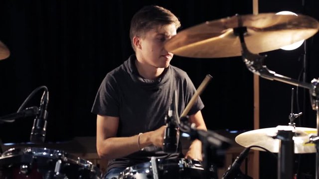 male musician playing drums and cymbals at concert