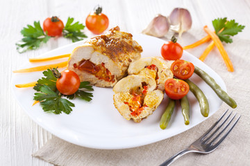 chicken rolls with tomato and paprika on white plate