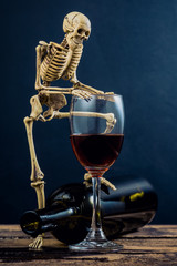 still life photography : drunkard human skeleton with wine glass and bottle