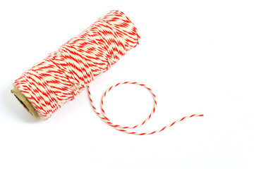 Roll of red and white rope on white background