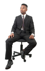 successful businessman in suit and tie seated on black chair on white background
