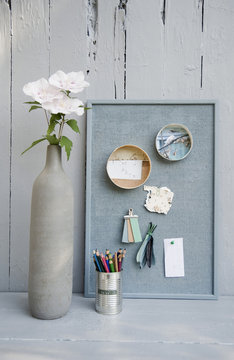 Mood board with photos, colored pencils, hibiscus blossoms, vase