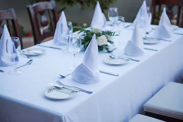 Festively laid table with white tablecloths  glasses and plates